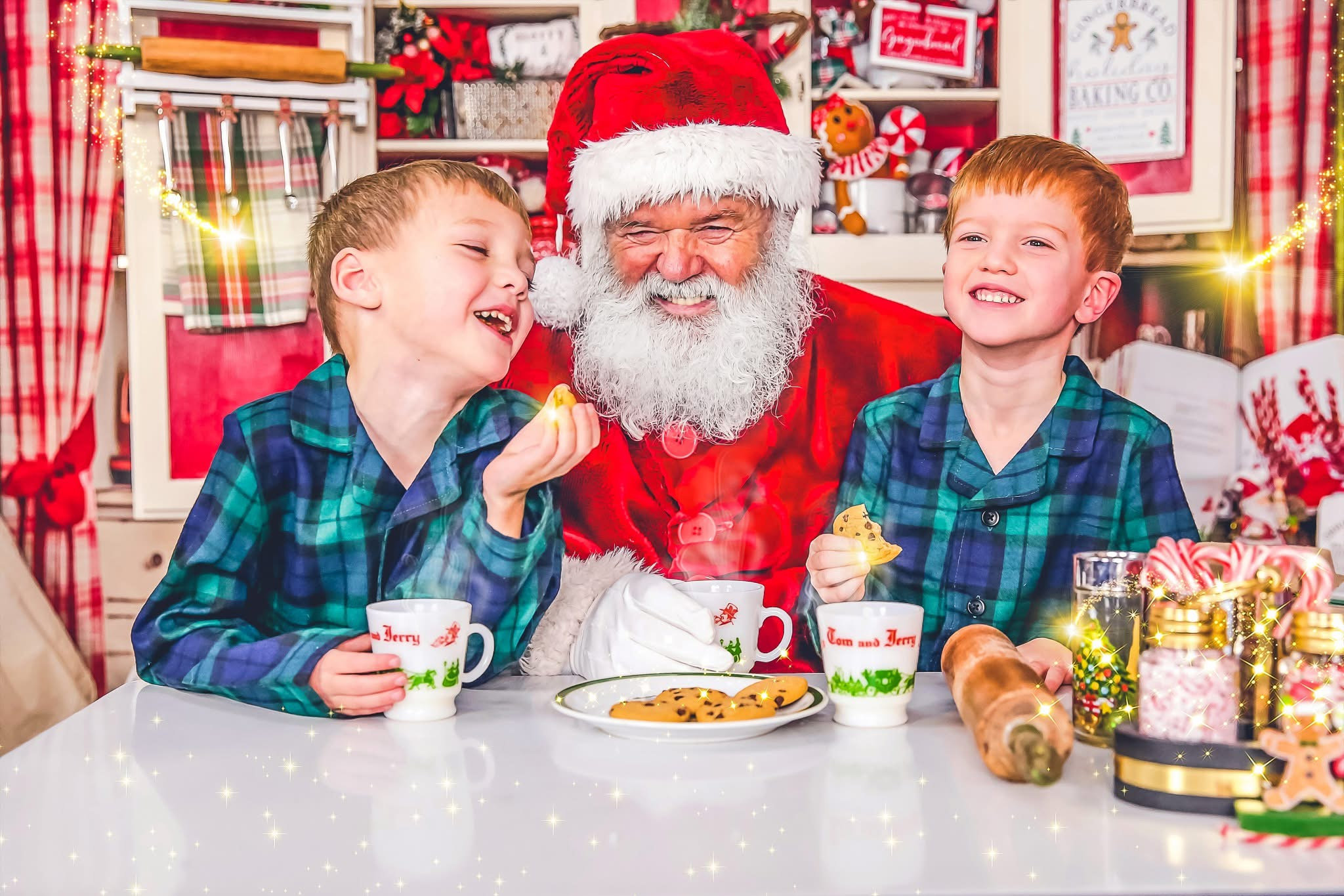 Two boys laughing with Santa over milk and cookies