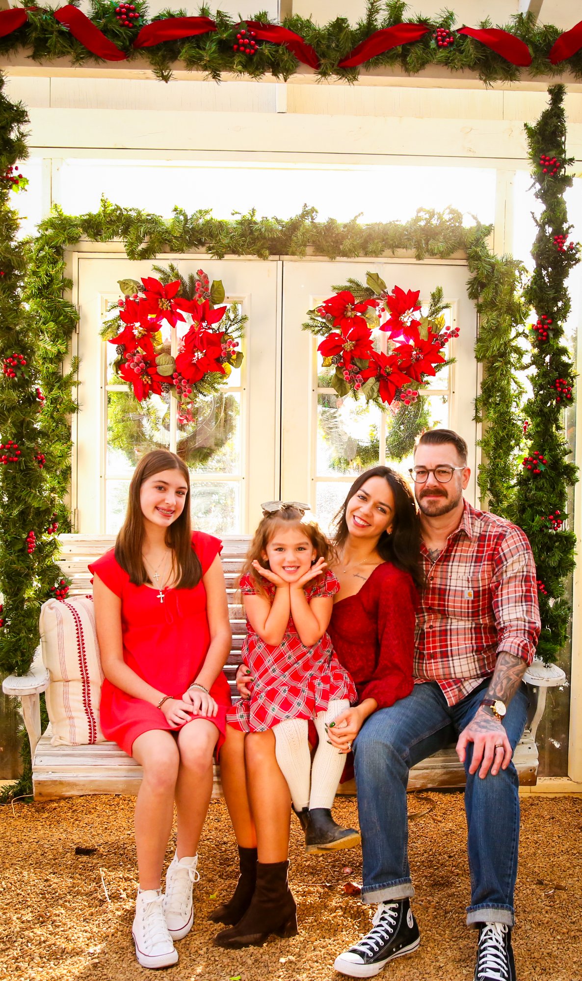 A family portrait on the swing beneath the wreaths