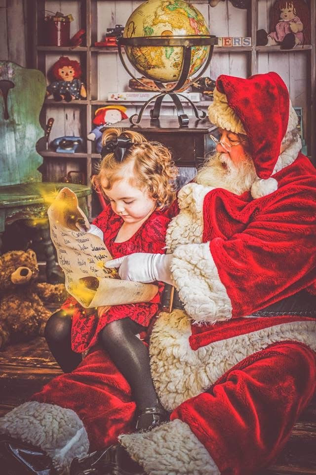 A little girl reading her Christmas list with Santa