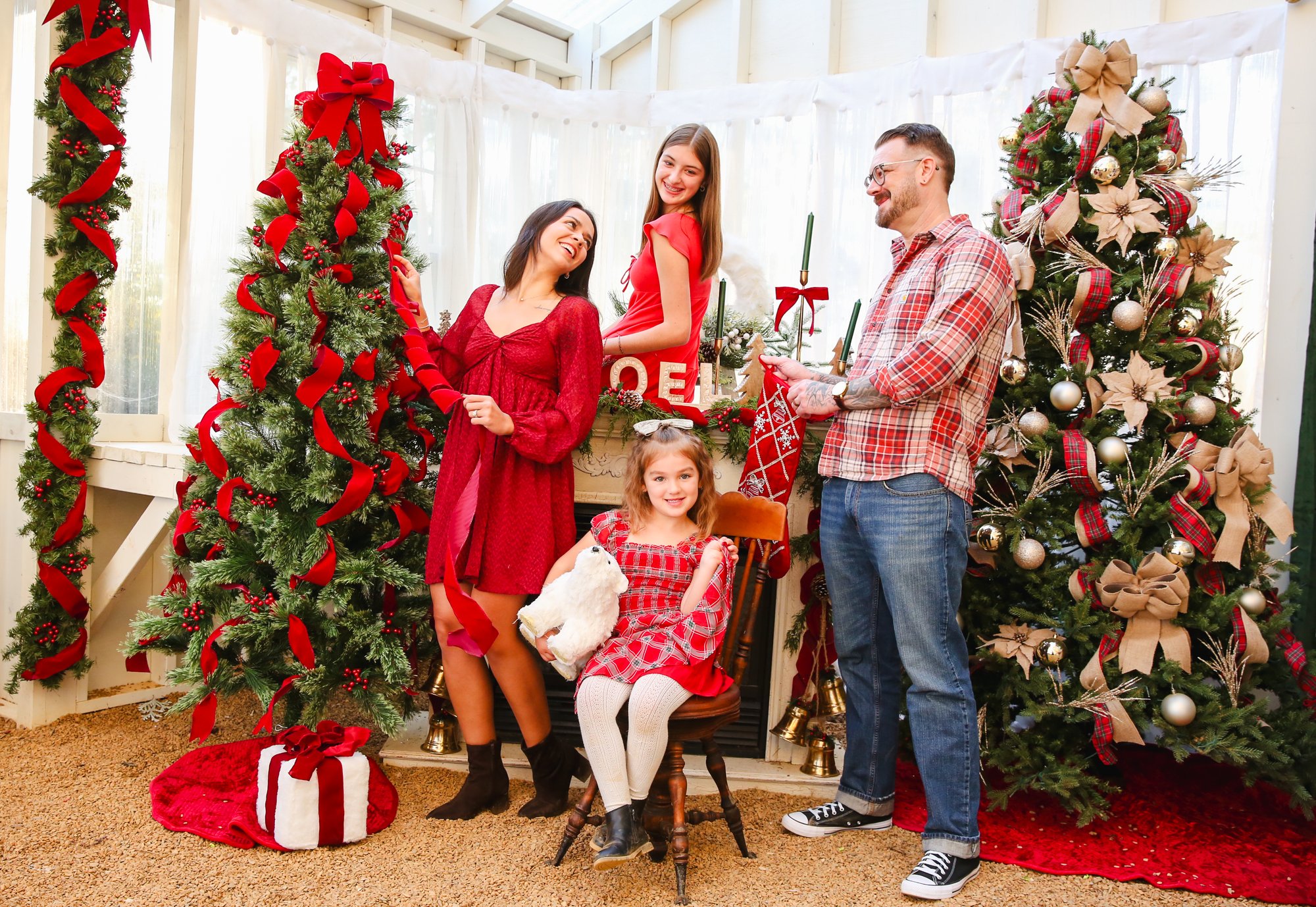 A family laughing beside the Noel mantel